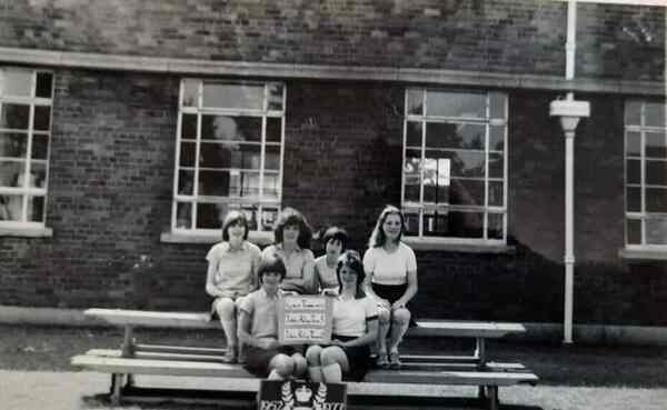 Six young girls from Winton High School in 1977 with a Queens Silver Jubilee Plaque.